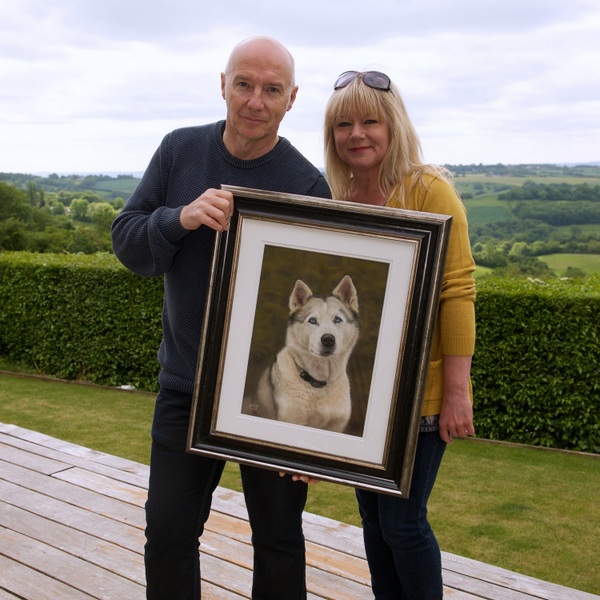 midge ure and helen chugg presenting a painting of a husky dog in Bath 